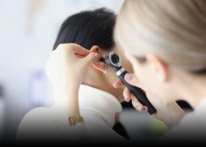 ENT specialist examining a patient's ear.